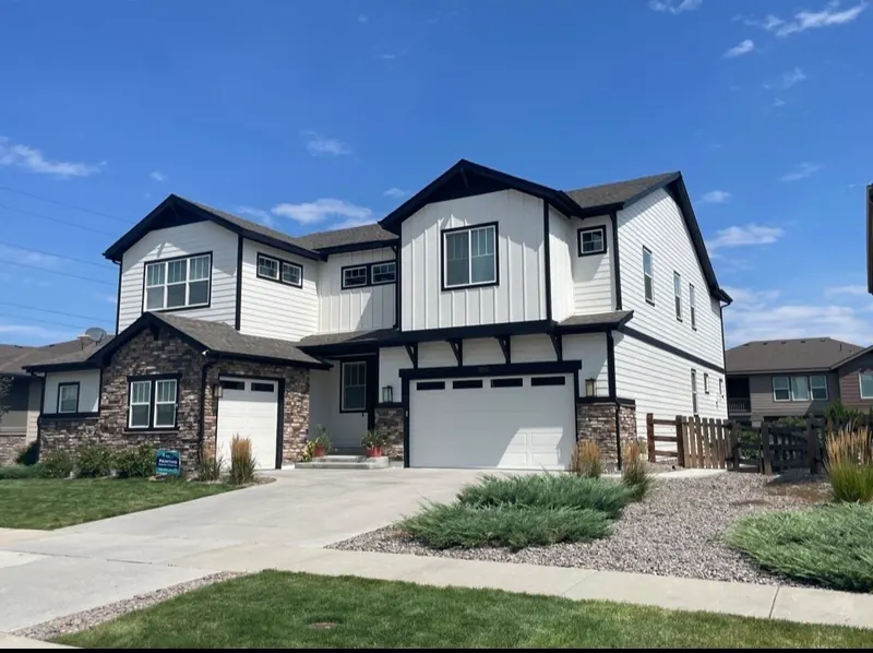 Repainted white two-story home with black trim and stone accents in Parker